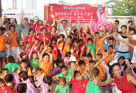 Paisan Bandityanon (back, center), owner of the Rabbit Resort in Jomtien Beach, along with hotel employees, children and care givers celebrate Chinese New Year.